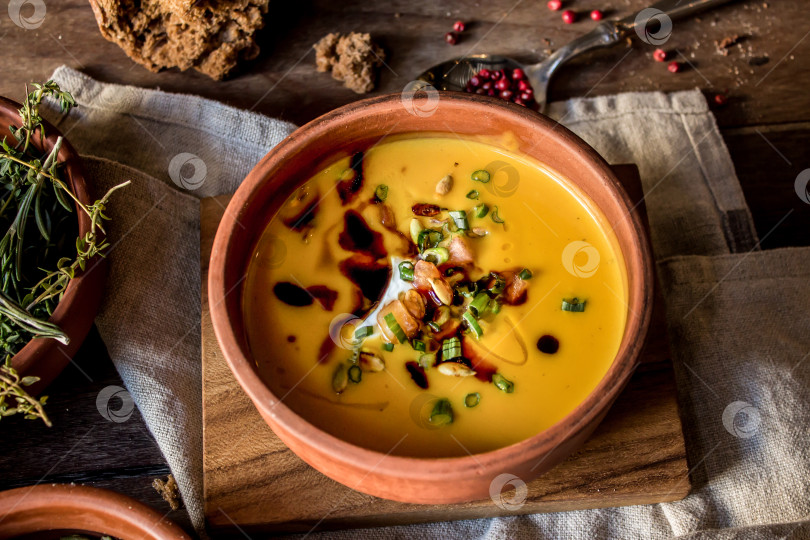 Скачать Тыквенный крем-суп со сливками и луком на темной деревянной основе фотосток Ozero