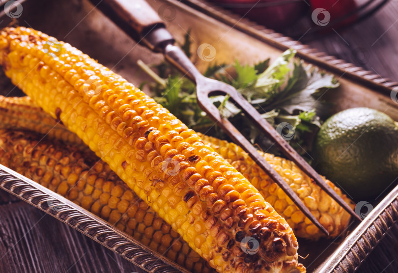 Скачать Запеченная кукуруза в винтажном блюде с лаймом фотосток Ozero