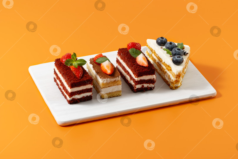 Скачать Клубничные и черничные пирожные на оранжевом фоне фотосток Ozero