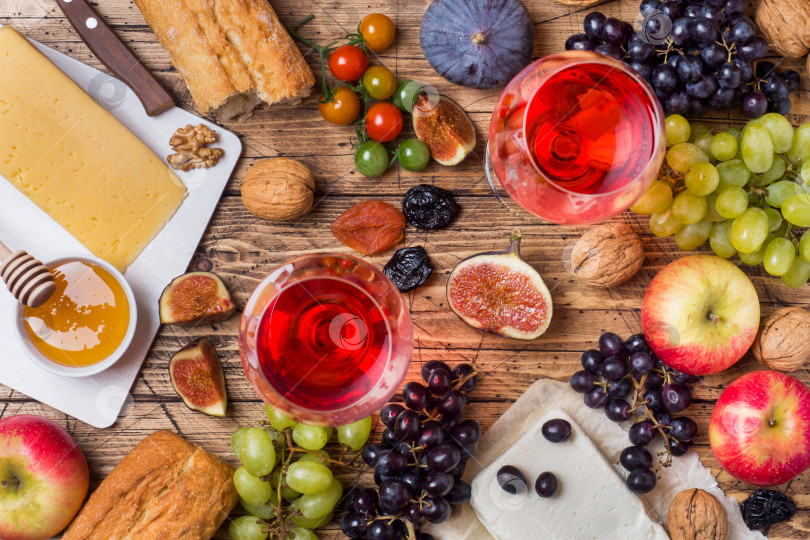 Скачать Сыр, вино, багет, виноград, инжир, мед и закуски на деревянном столе в деревенском стиле. фотосток Ozero