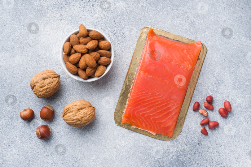 Скачать Продукты здорового питания с антиоксидантами: рыба и различные виды орехов на сером бетонном фоне. фотосток Ozero