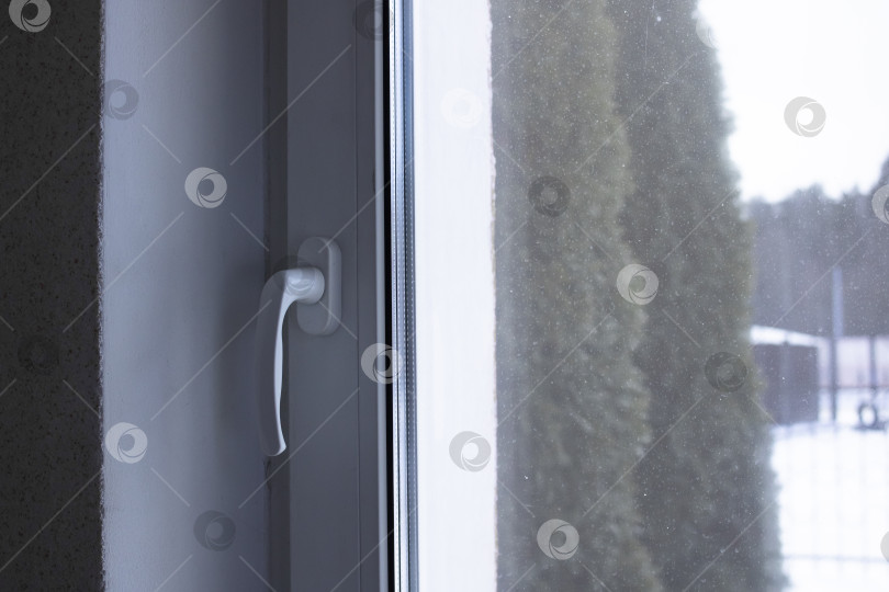 Скачать Ручка на закрытом окне на зимнем фоне фотосток Ozero