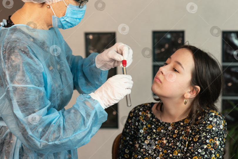 Скачать Врач берет мазок из носа девочки, делает анализ ДНК, ПЦР-тест. Медицинский медицинский холдинг COVID-19, набор для сбора мазков от коронавируса, ношение защитного костюма СИЗ, маски, перчаток, пробирки фотосток Ozero