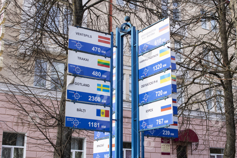 Скачать БЕЛАРУСЬ, ПОЛОЦК - 13 марта 2021 года: Указатели с флагами и названиями городов фотосток Ozero