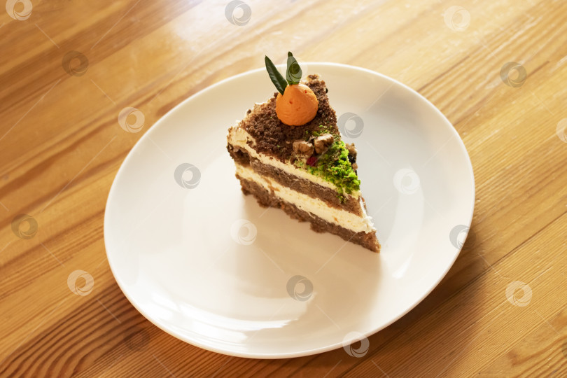 Скачать Кусочек морковного пирога на тарелке на деревянном столе фотосток Ozero