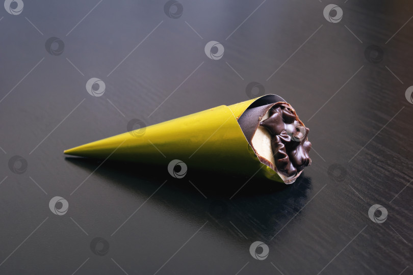 Скачать Шоколадная конфета в желтой обертке на деревянном столе фотосток Ozero