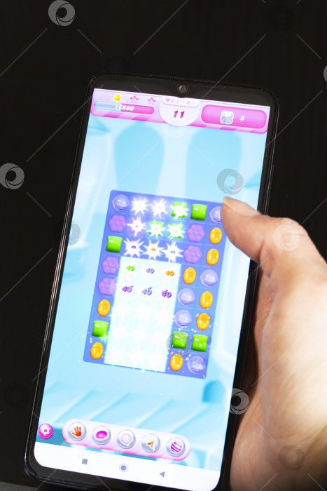 Скачать БЕЛАРУСЬ, НОВОПОЛОЦК - 27 марта 2021 года: игра Candy crush на дисплее телефона фотосток Ozero