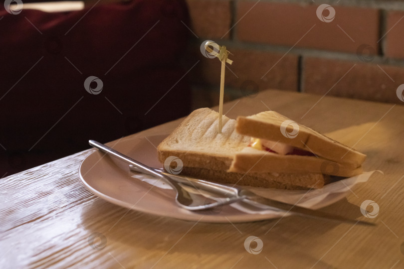 Скачать Два бутерброда с ветчиной и помидорами на тарелке на столе фотосток Ozero