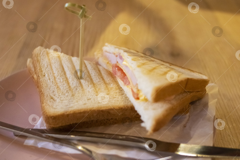 Скачать Два бутерброда с ветчиной и помидорами на тарелке на столе фотосток Ozero