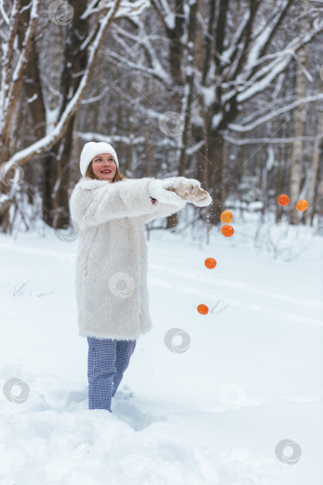 Скачать играет, бросая мандарины в снег в парке фотосток Ozero