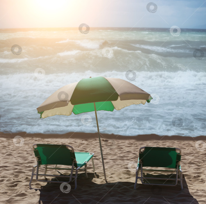 Скачать Два шезлонга и зонтик на песчаном пляже у моря фотосток Ozero