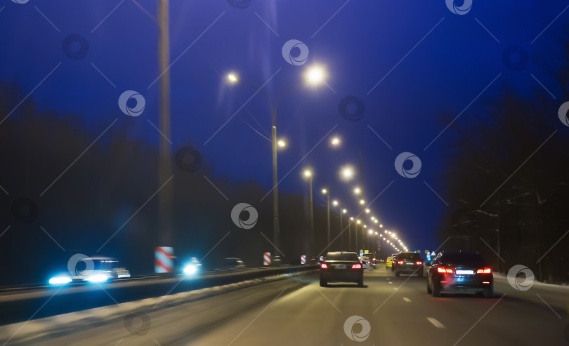 Скачать Автомобильное движение зимой по ночному шоссе. фотосток Ozero