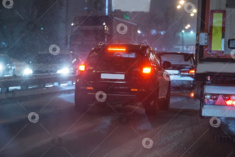 Скачать Движение по ночной зимней дороге во время снегопада фотосток Ozero