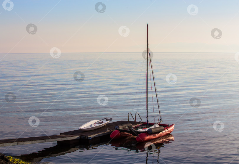 Скачать Парусный катамаран у пирса в море фотосток Ozero