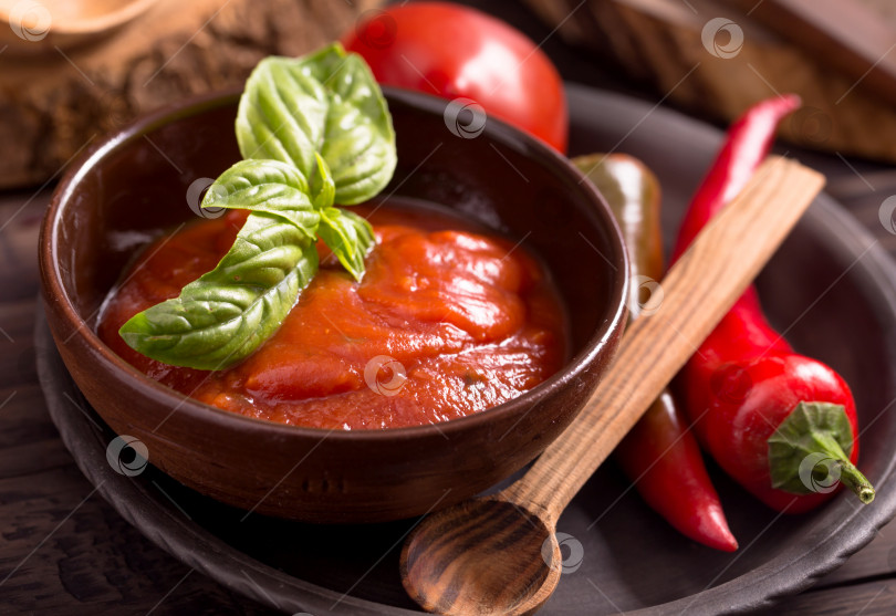Скачать Миска с томатным соусом и деревянная ложка фотосток Ozero