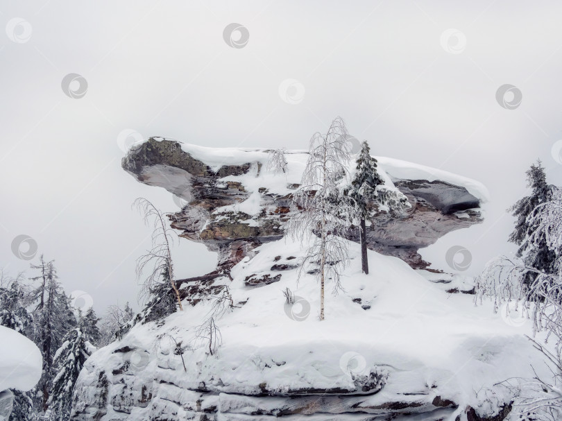 Скачать Большая гранитная скала замерзла и покрыта снегом. фотосток Ozero