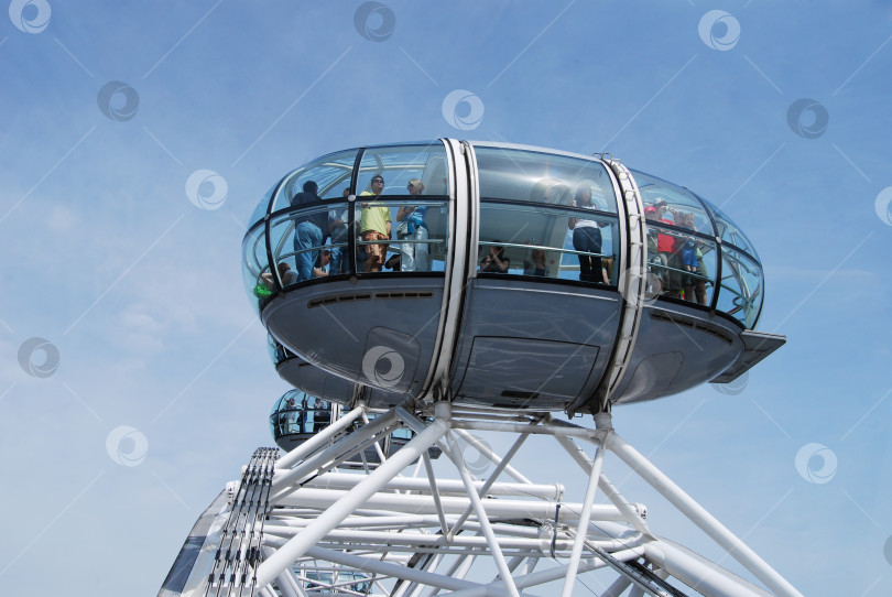 Скачать Лондон, Англия, Великобритания 23 мая 2009 года: Капсула London Eye приближается к самому верному положе-нию на кол-ве обозрения, в ней туристы любуются вид на город. фотосток Ozero