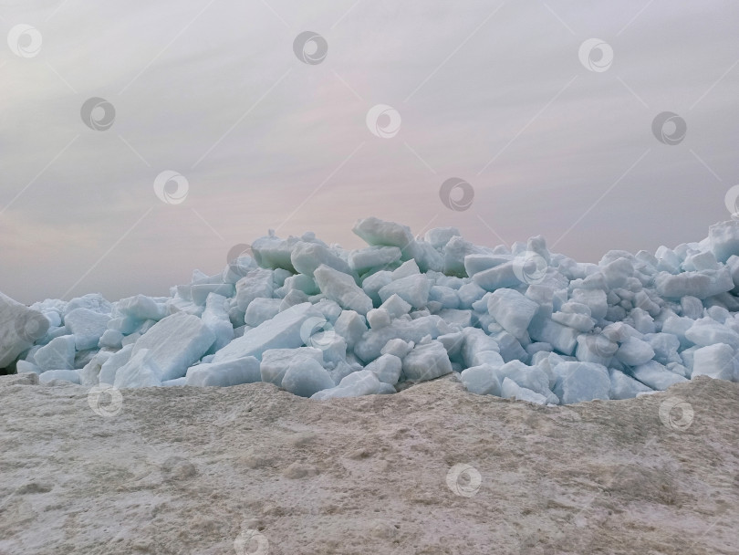 Скачать Груды льдин на берегу моря на фоне закатного неба фотосток Ozero