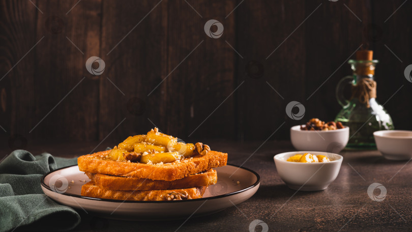 Скачать Тосты с карамелизированным бананом, медом и грецкими орехами на завтрак на веб-баннере table фотосток Ozero