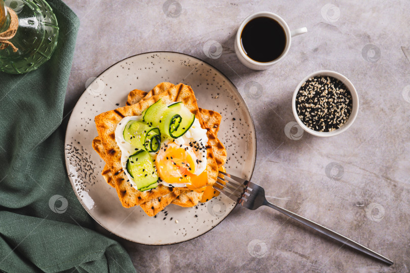 Скачать Тосты со сливочным сыром, огурцом, яйцом-пашот и кунжутом на тарелке вид сверху фотосток Ozero