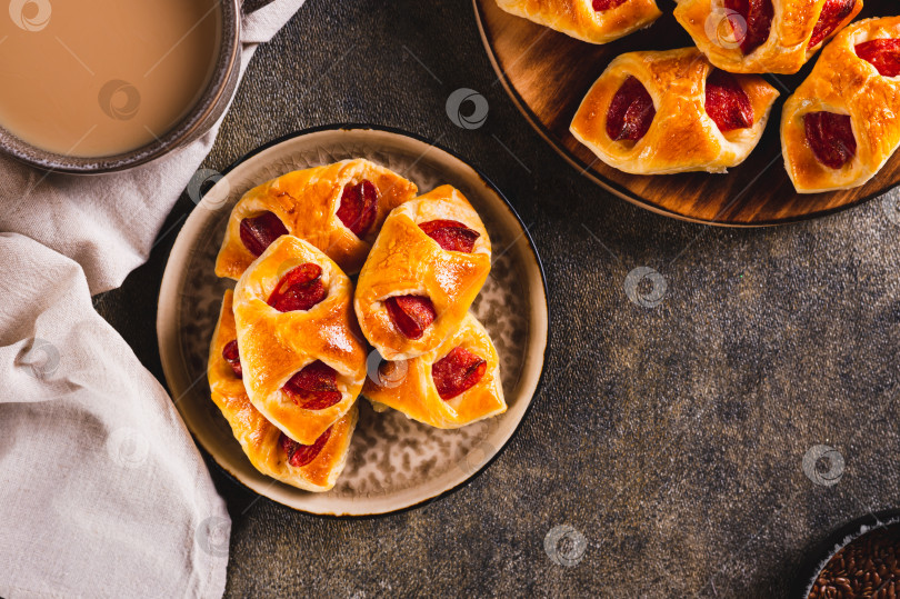 Скачать Аппетитные конвертики с сыром и колбасой пепперони на тарелке на столе вид сверху фотосток Ozero