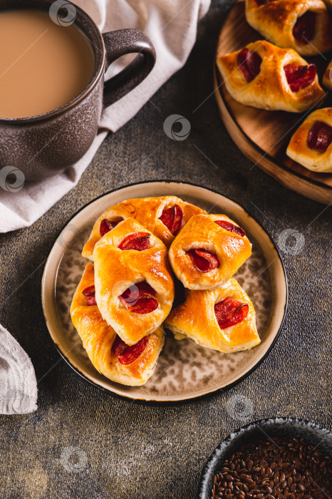 Скачать Булочки пепперони с сыром и колбасой на тарелке на столе вертикальный вид фотосток Ozero