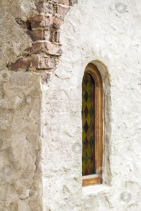 Скачать Архитектурные элементы стены, окна с цветными витражами. Старая стена с трещинами. фотосток Ozero