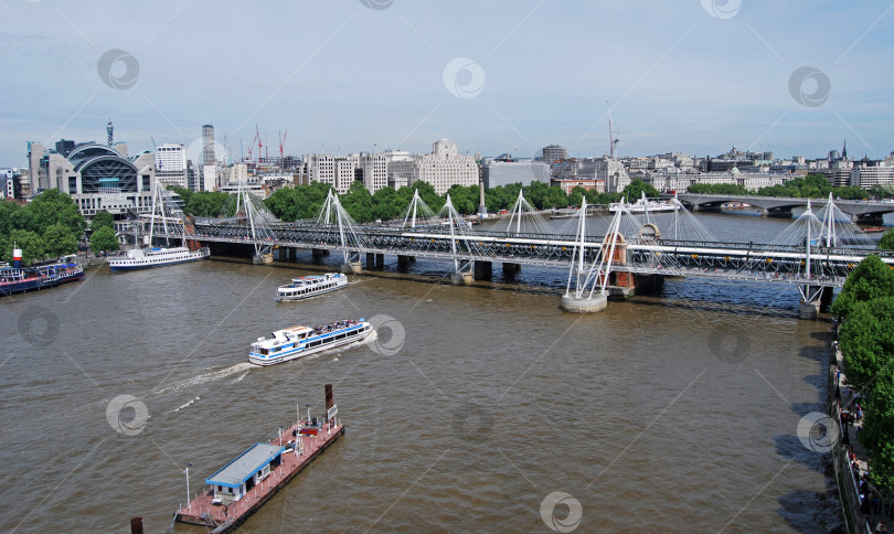 Скачать Лондон, Великобритания, 23 мая 2009: Речные суда плывут по Темзе в сторону железнодорожного моста Хангерфорд у станции Чаринг-Кросс фотосток Ozero