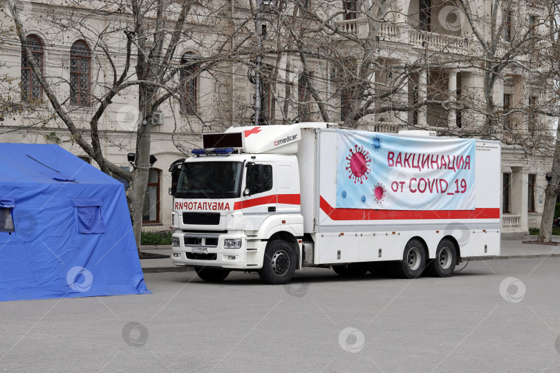 Скачать Медицинский автомобиль для вакцинации против Covid-19 в российском городе. перевод надписи: "вакцинация против Covid-19" фотосток Ozero