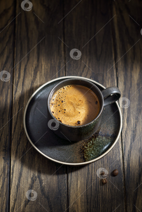 Скачать Чашка черного кофе с пеной на деревенском столе фотосток Ozero
