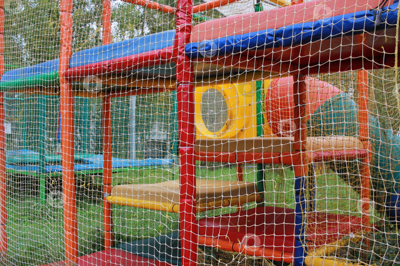 Скачать Фотография детской игровой площадки, огороженной сеткой. Бабуты. фотосток Ozero