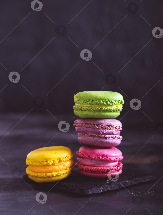 Скачать Разноцветное французское миндальное печенье на темном фоне фотосток Ozero