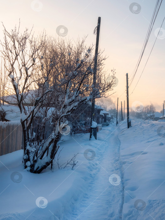 Скачать Замерзшая зимняя деревня, тропа через сугробы фотосток Ozero