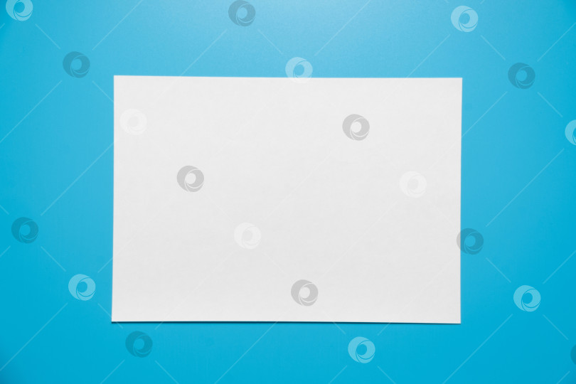Скачать Пустой лист белой бумаги, выделенный на синем фоне фотосток Ozero