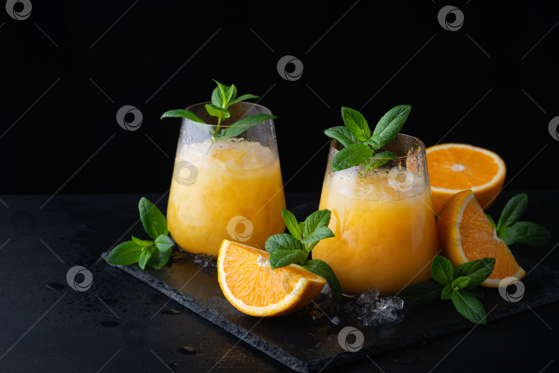 Скачать Холодный летний апельсиновый лимонад с мятой и льдом в бокале. фотосток Ozero