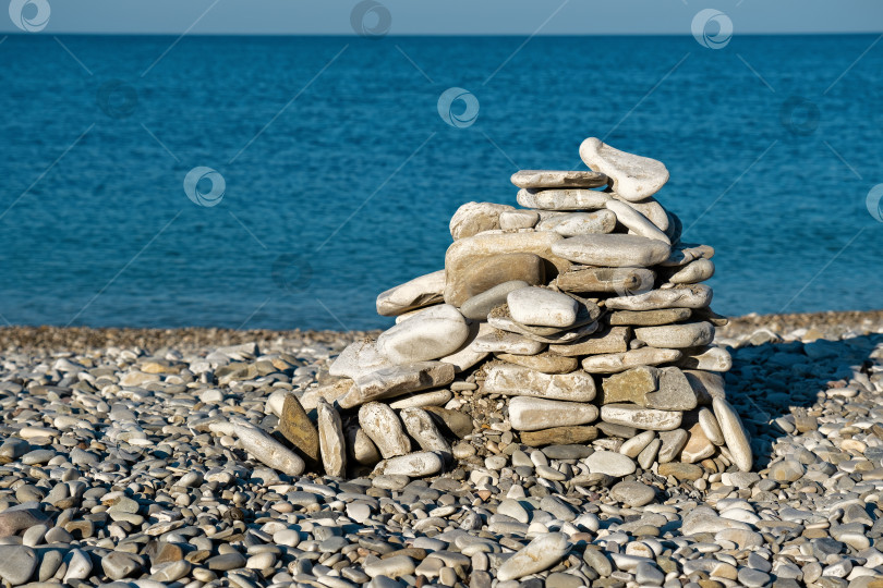 Скачать Сложенная из камней фигура на пляже фотосток Ozero
