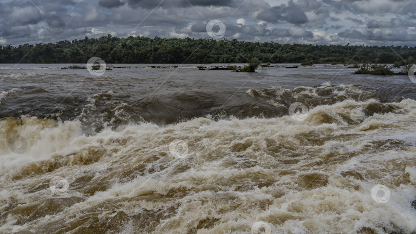 Скачать Бурный поток воды несется вдоль берега. фотосток Ozero