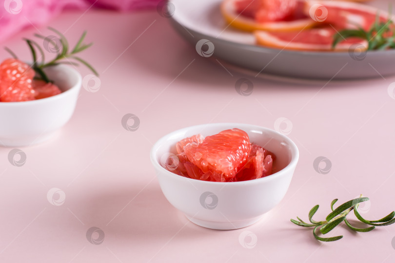 Скачать Очищенные кусочки грейпфрута и розмарина выложите в миску на столе. Ингредиенты для коктейля. фотосток Ozero