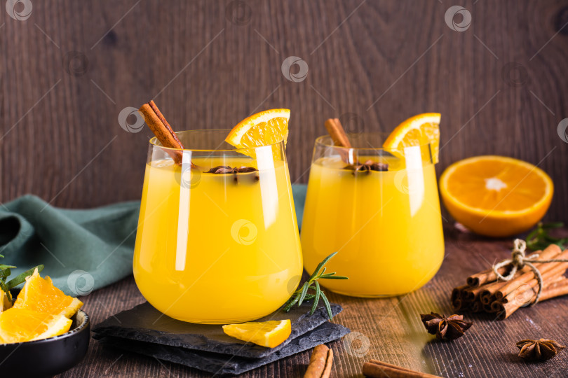 Скачать Апельсиновый грог с корицей и кардамоном в бокалах на столе. Домашние напитки фотосток Ozero