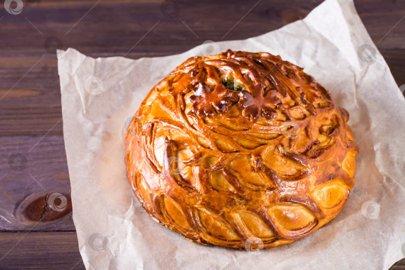 Скачать Домашний сытный пирог-курник с курицей, картофелем и рисом на пергаменте. фотосток Ozero