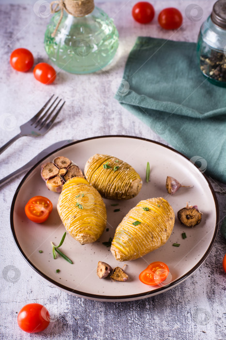 Скачать Запеченный картофель с чесноком и розмарином на тарелке. Домашний обед. Вид сверху фотосток Ozero