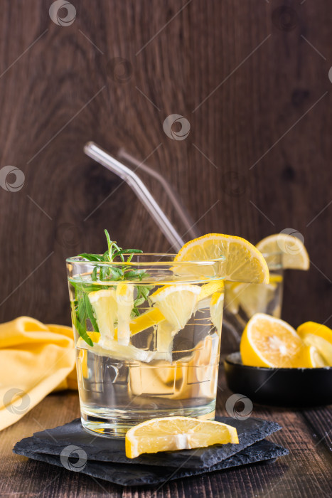 Скачать Вода с лимоном и розмарином в стаканах на столе. Детокс-напиток. Вид сверху фотосток Ozero