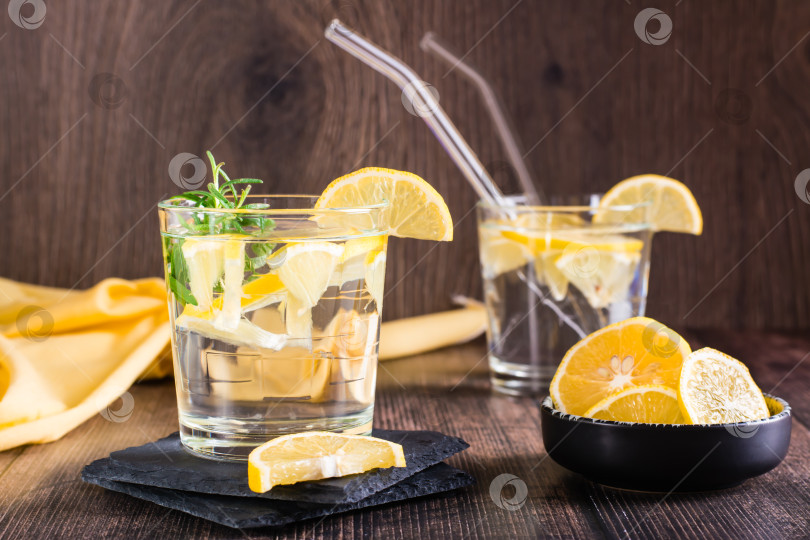 Скачать Вода с лимоном и розмарином в стаканах на столе. Детокс-напиток фотосток Ozero
