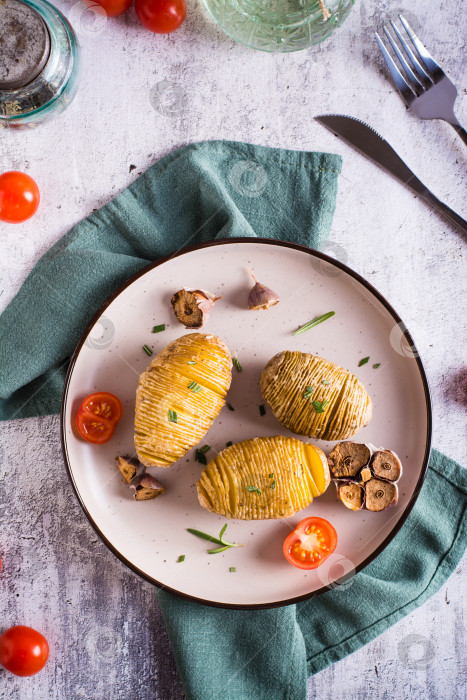 Скачать Запеченный картофель с чесноком и розмарином на тарелке. Домашний обед. Вид сверху и по вертикали фотосток Ozero