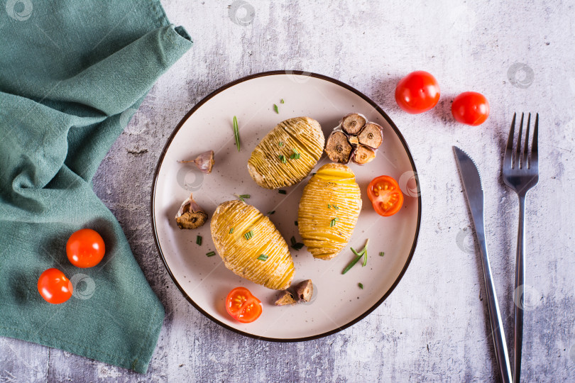 Скачать Вкусный домашний запеченный картофель с чесноком и розмарином на тарелке. Вид сверху фотосток Ozero