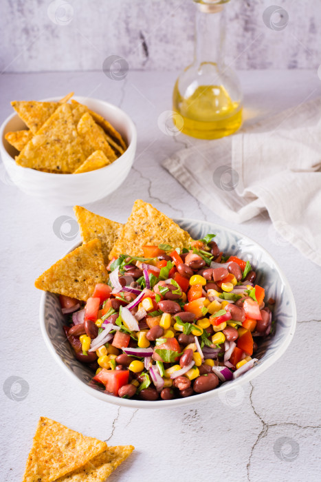 Скачать Домашняя ковбойская икра, традиционный мексиканский овощной салат и начос в миске. Вертикальный вид фотосток Ozero