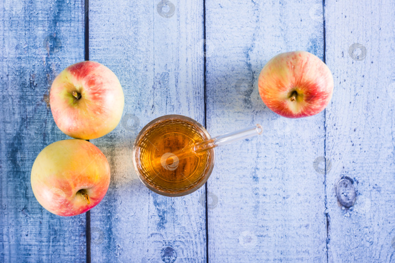 Скачать Свежевыжатый яблочный сок в стакане и фрукты на столе. Домашние напитки. Вид сверху фотосток Ozero