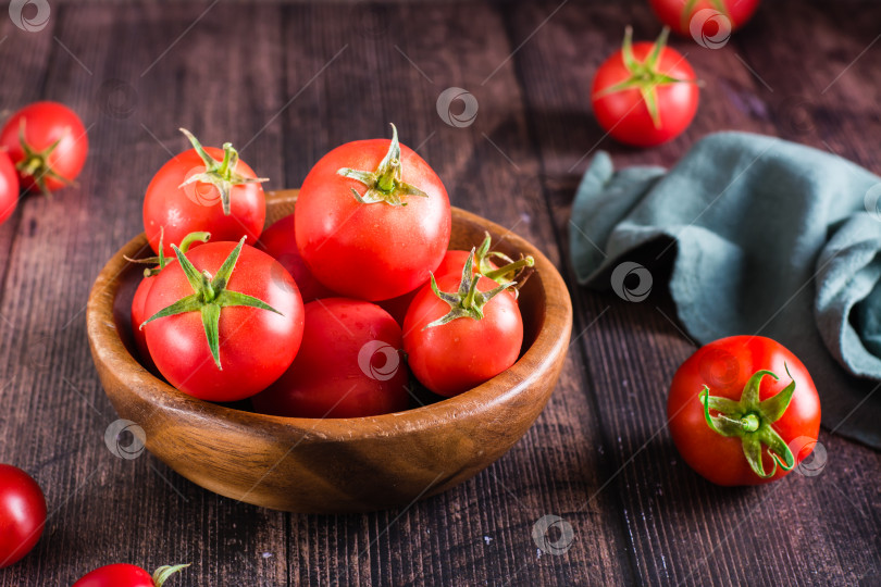 Скачать Спелые сырые целые помидоры в миске на деревянном столе. Соберите урожай из местных продуктов. фотосток Ozero