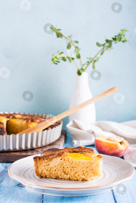 Скачать Кусок персикового пирога на тарелке на столе. Домашняя выпечка. Вертикальный вид фотосток Ozero