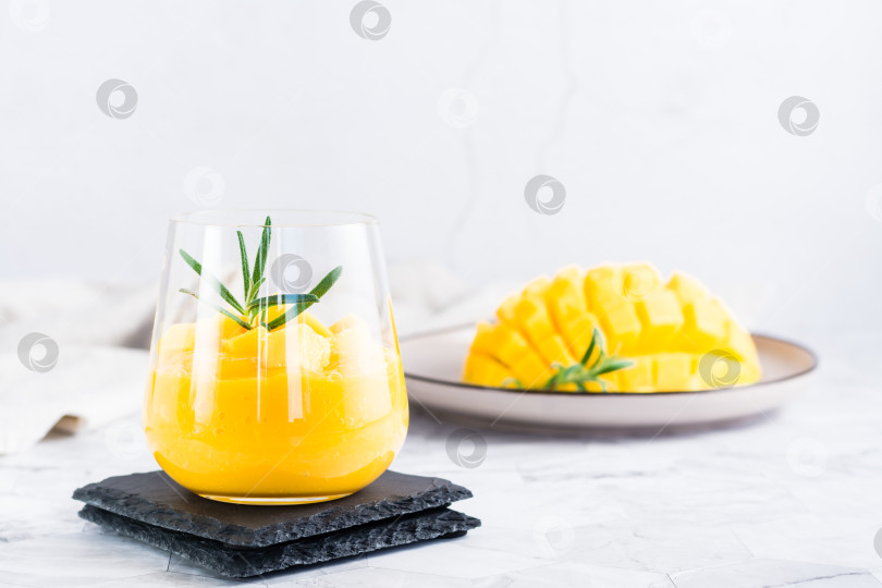 Скачать Смузи из свежего спелого манго в бокалах на столе. Домашний десерт фотосток Ozero